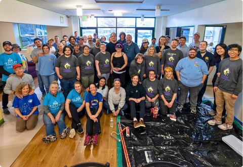 group poses after painting a nonprofit
