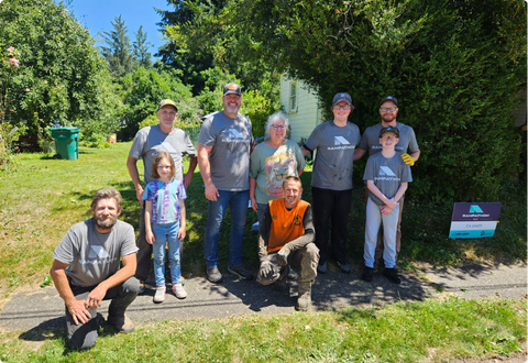 group poses on a homeowners lawn after building a ramp