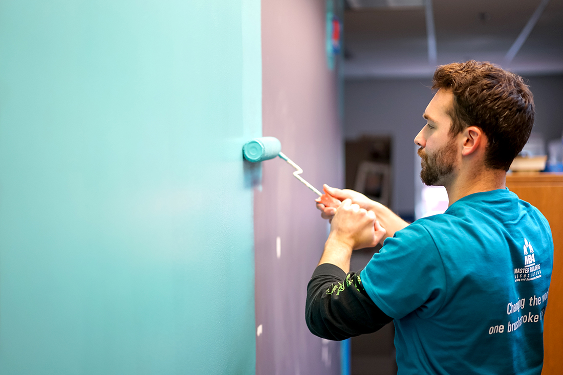 Volunteer paints a Kindering facility