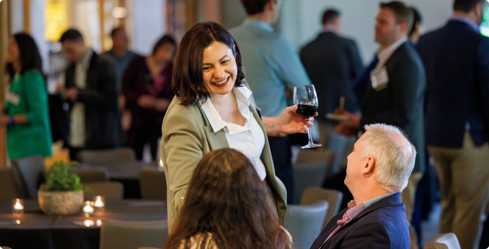 Woman with glass of wine at event meeting new people.