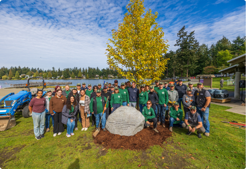 Volunteers gather around tree they just planted.