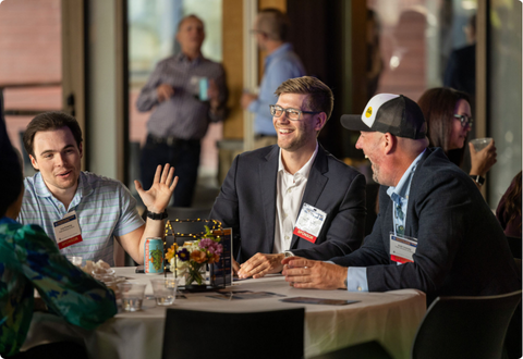 Three people on golf course at table.