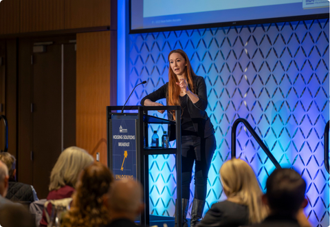 Three people standing behind informational table on golf course.