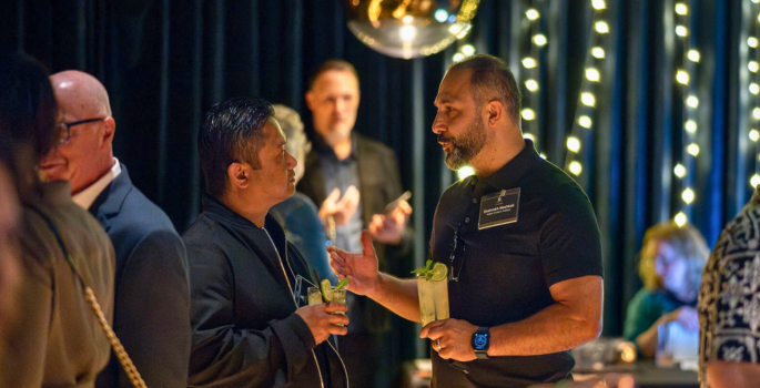 Two men talking with drinks.