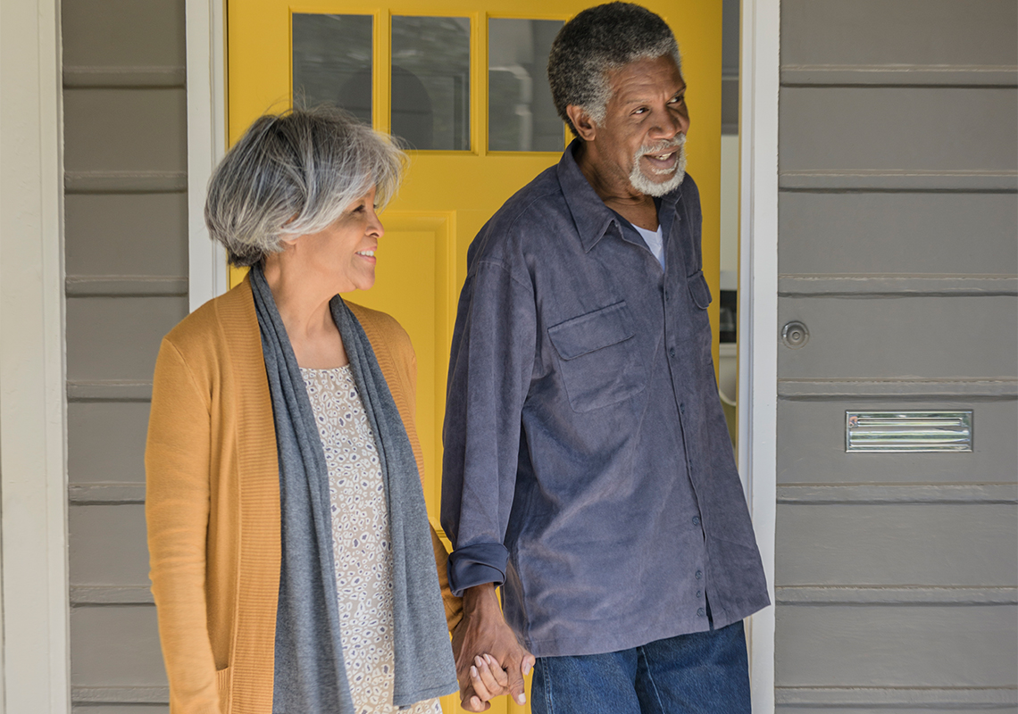 Black couple in front of their home