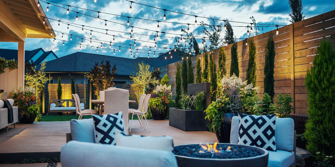 String lights over a modern patio with a fire pit