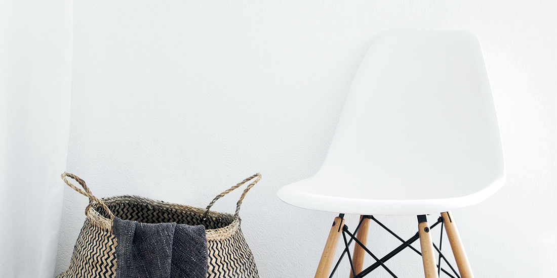 A chair and basket against a smooth wall