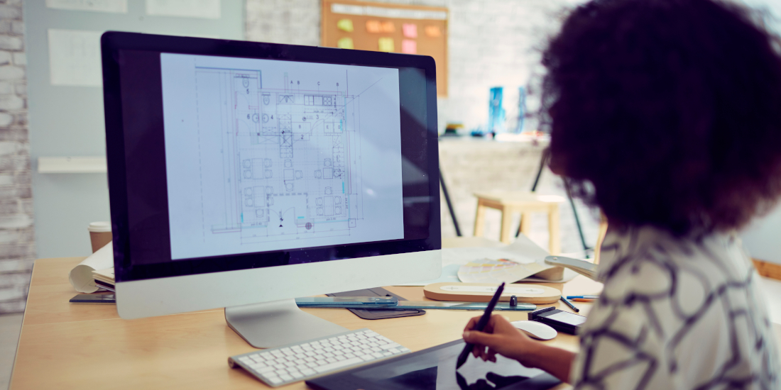 A designer working on plans at her desk