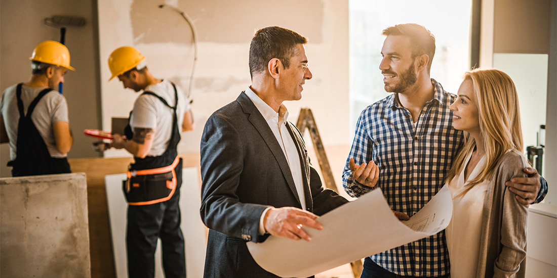 Remodeling clients smiling and discussing project with contractor